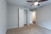 Located at 621 Memorial Dr in Red Bank, Tennessee, this single-floor home offers a well-organized layout with a clean, neutral aesthetic throughout. The open living and dining area is anchored by rich, dark hardwood flooring that reflects natural light from a window fitted with blinds. A stylish pendant light fixture serves as a focal point, while an open passage leads seamlessly toward the kitchen and entryway. The kitchen is efficiently designed, featuring gray cabinetry, light-toned countertops, and a full suite of stainless steel appliances including an electric range, over-the-range microwave, dishwasher, and refrigerator. The front entry door provides a welcoming transition from the exterior into the main living space. The bedrooms offer a comfortable contrast with soft, neutral carpeting underfoot, each room benefiting from natural light through window blinds and ceiling fans for year-round comfort. The home includes two bathrooms: one features a tub-shower combination with a decorative curtain and hardwood flooring, while the second is appointed with a dark-finished vanity, a large mirror, built-in shelving, and brushed nickel fixtures. The overall ambiance is practical and move-in ready, with a consistent neutral color palette that lends itself well to personalization.