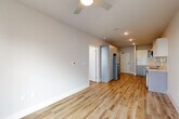 Located at 4854 Greenhouse Rd in Houston, TX, this thoughtfully designed one-bedroom, one-bathroom unit offers a clean, modern aesthetic across a single floor. The open-concept living and dining area features warm light wood flooring, a ceiling fan, and recessed lighting, creating a bright and welcoming atmosphere. The well-appointed kitchen is a standout, showcasing two-toned cabinetry — white upper shaker-style cabinets and gray lower cabinets — paired with a white quartz countertop, subway tile backsplash, and a full suite of stainless steel appliances including a gas range, built-in microwave, dishwasher, and refrigerator. The bedroom is carpeted for comfort, bathed in natural light from a large window with outdoor views, and includes a ceiling fan. A dedicated walk-in closet with dual shelving rods provides generous storage. The bathroom features gray vanity cabinetry, a white countertop, wood-look flooring, and subway tile detailing around the tub surround, with direct access to the walk-in closet. The unit also includes a laundry area and utility room, rounding out a complete and functional living space.