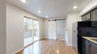 Located at 61560 Aaron Way in Bend, Oregon, this efficiently designed 2-bedroom, 1-bathroom unit makes excellent use of its single-floor layout. Light wood-tone flooring flows throughout the main living areas, lending warmth and continuity to the space. The open living area is bright and inviting, highlighted by recessed lighting and a sliding glass door that opens onto a private balcony with outdoor views of surrounding greenery. A distinctive black-hardware barn door serves as a stylish architectural accent, providing access between rooms while adding a modern-rustic touch.

The kitchen is well-appointed with dark cabinetry, granite-look countertops, a tile backsplash, and a full suite of stainless steel appliances including a refrigerator, range, microwave, and dishwasher. Recessed lighting illuminates the kitchen's functional layout, which connects seamlessly to the entry.

The two bedrooms offer a quiet retreat, with plush carpeting and windows that bring in natural light and views of the landscaped surroundings. The primary bedroom provides a comfortable and practical footprint.

The bathroom is clean and modern, featuring a walk-in shower with sliding glass doors, tile flooring, granite-look countertops, and brushed nickel fixtures, creating a cohesive, contemporary finish throughout.