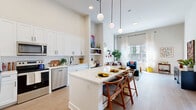 Located in Nashville's vibrant Midtown neighborhood, this one-bedroom, one-bathroom residence on Hayes Street offers a thoughtfully designed open-concept floor plan. The combined living, dining, and kitchen area forms the heart of the home, anchored by a striking kitchen featuring white shaker cabinetry, subway tile backsplash, stainless steel appliances, and a central island with bar seating illuminated by globe pendant lights. Soaring ceilings amplify the sense of space throughout, while light hardwood flooring ties the living areas together seamlessly. The living room is bathed in natural light from large windows and offers direct access to a private patio. A built-in desk nook provides a functional workspace adjacent to the kitchen. The bedroom features impressive ceiling height, an exposed concrete accent wall, large windows with outdoor views, and plush carpeting. It connects to a walk-in closet with wire shelving and a well-appointed bathroom with white cabinetry, a quartz countertop, matte black fixtures, a large mirror, and a tub/shower combo. In-unit laundry adds everyday convenience, completing this well-equipped Nashville residence.