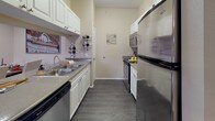 Located at 3515 S Nelson Cir in Denver, CO, this single-floor residence offers a thoughtfully designed layout with a warm, neutral color palette and dark hardwood-style flooring throughout the main living areas. The galley-style kitchen is efficiently arranged with white cabinetry, stainless steel appliances including a Whirlpool refrigerator, range, and microwave, along with a double stainless steel sink and a dishwasher — providing a fully equipped cooking space. Adjacent to the kitchen, the dining area accommodates a full-sized dining table and benefits from crown molding details that carry throughout the living spaces. The living room is bright and inviting, featuring crown molding, a ceiling fan, and sliding glass doors that open to a private outdoor balcony with views of the surrounding greenery. Two well-proportioned bedrooms are carpeted and filled with natural light from large windows, each equipped with a ceiling fan. The two bathrooms feature stone-tile flooring, vanities with ample counter space, and a shower/tub combination in the full bath. A dedicated in-unit laundry closet houses a full-sized washer and dryer, adding everyday convenience to this comfortable Denver residence.