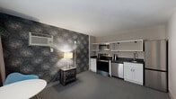 Located along the South Ocean Boulevard corridor in Myrtle Beach, SC, this two-bedroom, two-bathroom unit offers a well-organized layout across a single floor. The open living and kitchen area is visually striking, anchored by a bold floral-patterned accent wall that adds character and contrast to the neutral surroundings. The kitchen is fully equipped with stainless steel appliances — including a range, microwave, and dishwasher — complemented by dark countertops, white cabinetry, and open shelving for added storage and accessibility. A compact dining area with a round table and modern chair sits nearby, making the space functional for everyday living. The generously sized primary bedroom features the same distinctive floral wallpaper, creating a cohesive design thread throughout the unit. It includes a tufted upholstered headboard, a barn-style sliding closet door, a flat-screen TV atop a rustic dresser, and a leather loveseat, offering comfort and style. A secondary bedroom provides additional sleeping space. Both bathrooms are finished with floor-to-ceiling marble-look tile in the walk-in showers, pebble tile flooring, and teal accent walls that echo a coastal aesthetic. Soft carpeting throughout the living areas and bedrooms adds warmth to the overall design.