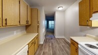 Located at 2809 S Emporia St in Wichita, KS, this single-floor apartment offers three bedrooms and one bathroom within a practical and efficiently arranged layout. The kitchen is well-appointed with warm oak-toned cabinetry providing generous upper and lower storage, white appliances including a range, dishwasher, and refrigerator, light countertops, and a double sink beneath a window. Wood-look plank flooring runs through the kitchen and connecting hallway, leading toward the carpeted living areas. The spacious primary bedroom offers ample room and is complemented by a dedicated closet with bifold doors. The two additional bedrooms are carpeted and each feature windows with blinds that allow natural light. Throughout, neutral beige and gray tones create a clean, understated aesthetic, accented by white trim and textured ceilings. The shared bathroom includes a full tub-shower combo and an overhead oak cabinet for storage. A closet provides added organizational space. The open flow between the living area and the bedrooms enhances the functional use of space throughout this well-maintained Wichita residence.