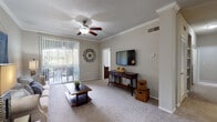 This single-story, 2-bedroom, 2-bathroom residence on McDaniel Road in Duluth, Georgia, offers a well-designed layout with a comfortable blend of functional spaces. The open-concept living and dining area serves as the heart of the home, featuring plush carpeting, crown molding, and a ceiling fan with light fixture. A sliding glass door floods the living room with natural light and provides access to a private balcony overlooking outdoor greenery. Decorative columns subtly define the transition between the living and dining zones, enhancing the sense of structure while maintaining an open feel.

The kitchen is equipped with white cabinetry, dark granite-style countertops, stainless steel appliances, and warm hardwood flooring, with a breakfast bar offering additional seating. Each bedroom is generously sized with plush carpet, ceiling fans, and windows that invite natural light. The bathrooms feature tiled tub-shower combinations with classic black accent tile detailing and hardwood flooring. A dedicated hallway with louvered closet doors provides convenient storage. The unit also includes an attached garage and a separate storage room, adding notable practical value to this well-appointed residence.