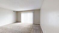 Located at 5235 SW 20th Terr in Topeka, Kansas, this single-floor, two-bedroom unit offers a practical and efficiently organized layout. The living room serves as the central gathering space, finished with neutral-toned carpet and a large sliding glass door fitted with vertical blinds, allowing natural light to fill the room while providing access to an outdoor area. The textured ceiling and warm wall tones carry throughout the space, lending a cohesive, understated aesthetic.

The kitchen is equipped with warm oak cabinetry extending to the ceiling for generous storage, black appliances including a refrigerator, range, and dishwasher, and light tile flooring that continues into the adjoining dining area. A ceiling fan with a light fixture overhead adds both functionality and air circulation to this space.

Both bedrooms are carpeted and feature windows with horizontal blinds that admit natural light. The primary bedroom offers a comfortable footprint, while the second bedroom is similarly appointed. Each bedroom benefits from dedicated closet access, contributing to the unit's practical storage capacity. A hallway connects the rooms, completing a straightforward and functional floor plan.