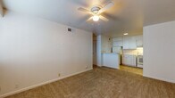 This single-floor, 1-bedroom, 1-bathroom unit offers a practical and comfortable layout designed for easy everyday living. The living area is spacious and open, featuring neutral-toned carpet underfoot and a ceiling fan with a light fixture overhead. The room flows seamlessly toward the kitchen, which is separated by a peninsula counter — ideal for casual dining or additional prep space. The kitchen is equipped with white cabinetry offering ample storage, white appliances including an electric coil range and dishwasher, light countertops, and tile flooring. A vent hood above the range adds functional convenience.

The bedroom is generously sized, carpeted, and benefits from a large window that allows natural light to fill the room. A ceiling fan provides comfortable air circulation, and a closet offers built-in storage.

The bathroom is clean and classic, featuring fully tiled walls surrounding a soaking bathtub and shower combination, white tile flooring, a toilet, and a vanity with mirror. The overall palette throughout the unit is bright and neutral, with white walls and light finishes creating a fresh, airy atmosphere. HVAC vents are present in each room, ensuring year-round climate comfort throughout the space.