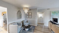 Located at 2501 E Little Creek Rd in Norfolk, Virginia, this single-floor, 3-bedroom, 2-bathroom home offers a thoughtfully designed layout with a variety of functional spaces. The combined living and dining area serves as the heart of the home, featuring light hardwood-style flooring, soft neutral gray walls with a chair rail accent, and a striking tiered chandelier that adds a touch of elegance. Natural light flows through multiple windows, creating a bright and welcoming ambiance throughout.

The spacious primary bedroom is carpeted for comfort and includes ample room for furnishings, with natural light provided by a large window. The additional bedrooms are equally well-sized, also featuring plush carpet and generous closet storage — five closets in total serve the home. A dedicated office space with large windows and hardwood-style floors provides an ideal work-from-home setup, while a secondary office nook offers built-in desk cabinetry.

The kitchen is equipped with warm wood cabinetry, granite-style countertops, and stainless steel appliances, with the added convenience of an in-unit washer and dryer. Both bathrooms are finished in clean white subway tile and modern fixtures. A utility room rounds out this functional and comfortable Norfolk home.