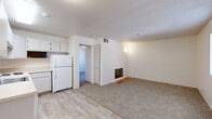 Located at 500 S Carmichael Ave in Sierra Vista, Arizona, this single-floor, one-bedroom, one-bathroom unit offers a practical and well-organized layout. The open living and kitchen area features a seamless transition between wood-style hard flooring and plush carpeting, with white cabinetry and a full-size refrigerator anchoring the kitchen space. A standout feature of the living area is a built-in fireplace with gold-framed glass doors set on a warm terracotta tile hearth, adding character to the space. Textured ceilings throughout lend a classic residential feel, while wall-mounted lighting provides a soft ambiance.

The bedroom is a comfortable, carpeted retreat featuring a window that frames views of the surrounding Arizona landscape, including distant mountains and mature trees. The room also benefits from a closet and direct access to the bathroom. The bathroom is efficiently designed with wood-look tile flooring, a vanity with a light blue cabinet base, and a full tub-shower combination with clean white tile surround. Natural light and mountain views make this a functional and pleasant unit ideally suited for those seeking straightforward, comfortable living in Sierra Vista.
