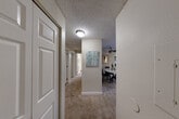 Located at 125 SW Campus Dr in Federal Way, WA, this 2-bedroom, 1-bathroom home offers a thoughtfully designed single-floor layout with a comfortable, functional flow throughout. The combined living and dining area serves as the heart of the home, anchored by a tiled fireplace with a classic white mantle and complemented by plush carpeting and a large window that invites natural light and outdoor views. A ceiling fan adds year-round comfort to the space. The kitchen features rich dark cabinetry, light countertops, stainless steel appliances, and wood-look flooring, with a window above the sink providing additional brightness. It opens conveniently toward the dining area for easy entertaining. The primary bedroom is a well-proportioned retreat with a window overlooking greenery, plush carpet, and access to ample closet space. The second bedroom is versatile and similarly comfortable. The bathroom is finished with wood-look tile flooring, dark wood vanity cabinetry, and a full soaking tub. A central hallway connects the rooms efficiently, lined with six closets offering exceptional storage. Additional highlights include a private balcony, in-unit laundry, and a textured ceiling throughout.