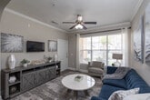 This single-floor residence offers a thoughtfully designed open-concept layout that seamlessly connects the living, dining, and kitchen areas. The living room is anchored by crown molding, a ceiling fan, and a large window that invites natural light and outdoor views, creating a bright and welcoming atmosphere. An elegant arched passageway frames the transition between the living and dining spaces, adding a distinctive architectural touch. Hardwood-style flooring runs throughout the main living areas, lending warmth and continuity to the space.

The kitchen is well-equipped with rich, dark wood cabinetry, white countertops, a subway tile backsplash, and a full suite of black Whirlpool appliances, including a refrigerator, range, and over-the-range microwave. A peninsula with pendant lighting provides additional prep space and opens to the dining area, making it ideal for both everyday meals and entertaining.

The bedroom features carpeted flooring, a ceiling fan, and a window with outdoor views. It connects directly to an en-suite bathroom, which includes a long double-sink vanity with dark cabinetry and white countertops. A walk-in closet provides generous storage. Completing the unit is a dedicated in-unit laundry area with a full-size washer and dryer and built-in shelving overhead.