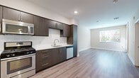 Located in the heart of Los Angeles' vibrant Little Tokyo neighborhood, this well-designed one-bedroom, one-bathroom unit offers a thoughtful layout across a single floor. The open-concept living and kitchen area sets a modern tone, featuring light wood-style flooring that flows throughout the main spaces and creates a clean, cohesive aesthetic.

The kitchen is a standout feature, equipped with sleek dark-wood cabinetry that extends to the ceiling for ample storage, a crisp white subway tile backsplash, white quartz-style countertops, and a full suite of stainless steel appliances including a gas range, built-in microwave, dishwasher, and refrigerator. The living area is bright and open, benefiting from natural light streaming in through a window with outdoor views.

The bedroom is a comfortable, carpeted retreat with soft neutral tones, a window with views of the surrounding area, and a dedicated closet for storage. A hallway connects the bedroom to the full bathroom, which includes a tub-shower combination, a wall-mounted storage cabinet with dark wood finish, and clean white tile surround. Throughout the unit, white baseboards, neutral walls, and consistent finishes contribute to a modern and move-in ready ambiance.