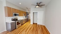 This 340 square foot studio apartment in Edina, Minnesota, offers a thoughtfully designed living space that maximizes efficiency without compromising on style. The open-concept layout seamlessly integrates the kitchen, living area, and sleeping space.

The kitchen is a standout feature, boasting sleek wooden cabinetry with a two-tone design. Upper cabinets in warm wood tones complement the lower cabinets in a modern grey finish. Stainless steel appliances, including a refrigerator, dishwasher, and range with microwave, add a contemporary touch. The white quartz countertops and subway tile backsplash create a bright, clean aesthetic.

The bathroom, though compact, is well-appointed with a single vanity, toilet, and shower. It mirrors the kitchen's color scheme with grey cabinetry and white countertops. Both the kitchen and bathroom feature the same warm-toned hardwood flooring that runs throughout the apartment, creating a cohesive look.

The main living area is bright and airy, with neutral walls and ample natural light. A ceiling fan adds both style and functionality. The space includes a closet for storage, cleverly tucked away behind sliding doors.

Despite its small footprint, this studio apartment feels spacious and inviting, perfect for modern, minimalist living in a prime Edina location.