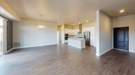 Located at 1455 W Lake St in Minneapolis, this thoughtfully designed single-floor residence combines modern aesthetics with functional living. The expansive main living area is anchored by a striking dark-accented fireplace wall flanked by large windows that flood the space with natural light and offer views of the surrounding cityscape. Rich, dark hardwood-style flooring extends throughout the living areas, complemented by a contemporary chandelier. Sliding glass doors open to a private balcony, extending the living space outdoors.

The gourmet kitchen is outfitted with white flat-panel cabinetry, quartz countertops, a large center island with an undermount sink, stainless steel appliances including a gas range and wall oven, a sleek range hood, and globe pendant lighting above the island. A subtle tile backsplash adds texture and refinement.

The bedroom features plush carpeting, a tray ceiling, and generous sliding glass doors leading to a private outdoor terrace with open city views. Walk-in closets with extensive wire shelving systems provide ample storage throughout.

The bathroom is finished with crisp white subway tile surrounding a soaking tub, neutral floor tile, a vessel sink set into a white vanity, and polished chrome fixtures, creating a clean and serene retreat.