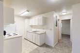 Located at 922 North Pearl Street in Tacoma, WA, this single-floor, one-bedroom, one-bathroom unit offers a practical and comfortable layout. The living room is a welcoming, carpeted space with a textured ceiling, baseboard heating, and a large window that brings in natural light and outdoor views of the surrounding neighborhood. The open sightline from the living area into the kitchen creates a connected, airy feel. The kitchen is efficiently designed with white cabinetry lining both walls, ample upper and lower storage, light countertops, a stainless steel sink, a dishwasher, and a freestanding electric range with a refrigerator — all set on easy-care tile flooring. The bedroom is a comfortably sized, carpeted retreat featuring a window with neighborhood views and baseboard heating. Three closets throughout the unit provide generous storage options. The bathroom includes a single-sink vanity with white cabinetry, a full tub-shower combination, tile flooring, and a large mirror. Throughout the unit, a neutral color palette of whites and soft grays creates a clean, cohesive aesthetic that is move-in ready and easy to personalize.