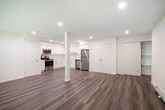 Located in Moriches, NY, this single-floor unit offers a clean, modern layout designed for comfortable everyday living. The open-concept kitchen serves as the heart of the space, outfitted with crisp white shaker cabinetry, light-toned countertops, and a full suite of stainless steel appliances including a refrigerator, range, microwave, and dishwasher. Recessed lighting illuminates the area, and durable wood-look luxury vinyl plank flooring extends throughout the main living areas, adding warmth and cohesion to the design. An in-unit laundry area with washer and dryer is conveniently accessible from the kitchen, enhancing daily functionality. The living areas are bright and open, with natural light filtering in through multiple windows that offer views of the surrounding neighborhood. The bedrooms are carpeted for comfort, each featuring a window with natural light, baseboard heating, and wall-unit air conditioning. The primary bedroom includes a generous closet with sliding doors and direct access to adjacent rooms. The full bathroom is finished in a clean, all-white palette with a single-sink vanity, toilet, and a tub-shower combination. Throughout the unit, neutral tones and consistent finishes create a cohesive and move-in-ready environment.