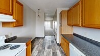 Located at 2725 S Emporia St in Wichita, Kansas, this single-floor, two-bedroom, two-bathroom residence offers a practical and well-organized layout. The kitchen is equipped with warm honey-toned oak cabinetry, dark granite-style countertops, white appliances including an electric range and refrigerator, and durable wood-look flooring that extends through the main living areas. A pendant light adds a subtle decorative touch above the kitchen corridor, which opens toward the living area.

Both bedrooms feature neutral-toned carpet, textured ceilings, and windows that bring in natural light. The primary bedroom includes direct access to one of the two bathrooms as well as a dedicated closet, offering added convenience. The second bedroom features a sliding double-door closet, providing ample storage. Both bathrooms are finished with clean, white tub-shower combinations and wood-look tile flooring, lending a cohesive and tidy aesthetic throughout.

The overall color palette is light and neutral, with warm beige walls and white trim creating a calm, understated ambiance. The efficient floor plan makes thoughtful use of every room, making this a well-appointed and functional living space in Wichita's south side.