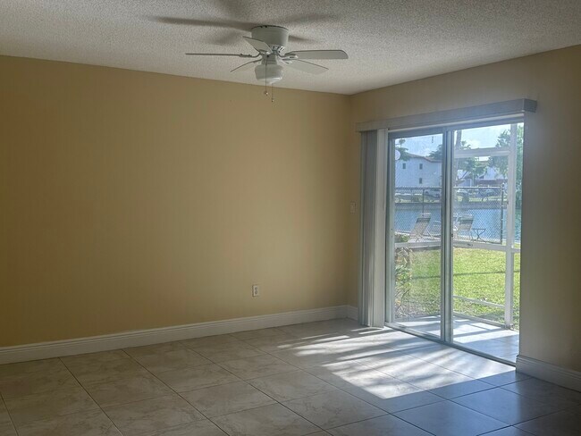 Sala de estar con vistas a la piscina y al lago. - 21121 SW 85th Ave