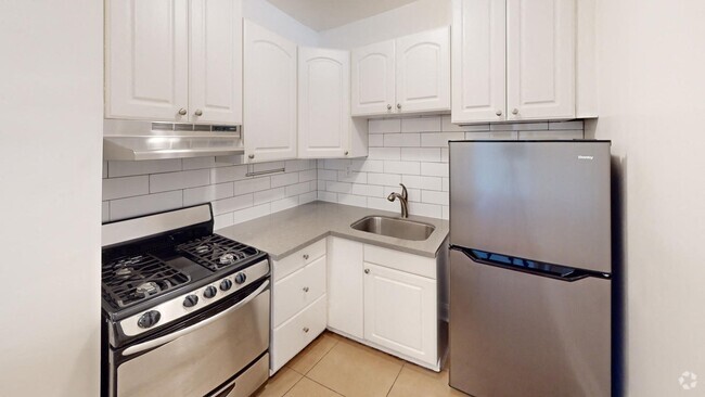 Kitchen with multiple cabinets, refrigerator, stove, range hood, and sink - 645 Stockton St