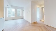 Located at 229 Adelaide St W in Toronto's vibrant Financial District, this thoughtfully designed one-bedroom, one-bathroom unit offers a clean, contemporary aesthetic throughout. The entire space is unified by striking light oak herringbone-patterned hardwood flooring, lending a refined and modern character to every room.

The open living area is bright and airy, benefiting from large windows that frame dynamic city skyline views, filling the space with natural light. The minimalist white walls complement the warm tones of the flooring, creating a calm and functional environment.

The bedroom is a compact yet efficient retreat, featuring a built-in sliding closet and the same herringbone flooring that runs throughout the unit. Its clean, unadorned walls provide a versatile canvas for personalization.

The bathroom is finished with neutral stone-look floor tiles, sage green vertically stacked wall tiles surrounding the soaker tub, and a sleek dark-toned vanity with an illuminated mirror. Matte black fixtures add a contemporary contrast throughout.

A dedicated laundry closet in the hallway houses a stacked washer and dryer unit, offering the convenience of in-suite laundry within a well-organized layout. Recessed lighting in the hallway and throughout enhances the clean, modern finish of this efficiently planned downtown Toronto residence.