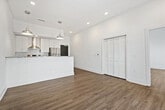 This well-appointed 1-bedroom, 2-bathroom residence offers a clean, modern aesthetic with a thoughtfully designed open-concept layout. Light wood-tone flooring flows consistently throughout, complementing the crisp white walls and creating a bright, airy atmosphere.

The kitchen serves as a central focal point, showcasing granite countertops, white shaker-style cabinetry, a white subway tile backsplash, and a full suite of stainless steel appliances including a refrigerator, range, and dishwasher. A peninsula with pendant lighting above provides additional prep space and serves as a natural divide between the kitchen and the living area.

The living area is generously proportioned, featuring a ceiling fan and a sliding glass door that invites natural light and offers outdoor views. The bedroom is comfortably sized with vaulted ceilings, a ceiling fan, and multiple windows that frame exterior views, creating a bright and open feel. A dedicated closet provides practical storage.

Both bathrooms are finished with consistent materials — granite vanity countertops, white subway tile, and light tile flooring. One bathroom features a full soaking tub with a shower combination, while the second bathroom connects conveniently to the bedroom, offering added functionality and privacy.
