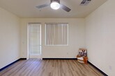 Located at 4910 W Glenn Dr in Glendale, Arizona, this two-bedroom, one-bathroom single-floor home offers a practical and modern layout with clean, contemporary finishes throughout. The open-concept living and kitchen area serves as the heart of the home, featuring light wood-look luxury vinyl plank flooring, neutral cream walls, and a ceiling fan that promotes airflow and comfort. The kitchen is well-appointed with abundant gray shaker-style cabinetry, white quartz countertops, a full suite of white appliances including a refrigerator, dishwasher, and range, as well as a central island with pendant lighting — ideal for both meal prep and casual dining. The living area benefits from natural light through a large window with vertical blinds and direct access to an exterior door. Both bedrooms are carpeted and fitted with ceiling fans and windows with vertical blinds for light control. The primary bedroom includes a dedicated closet, while the secondary bedroom offers a double-door closet for ample storage. The full bathroom features LVP flooring, a vanity with light countertops, gray cabinetry, and a tub-shower combination. The overall ambiance is bright, clean, and move-in ready, with a cohesive design aesthetic that balances functionality with modern style.