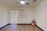 Located at 4910 W Glenn Dr in Glendale, Arizona, this two-bedroom, one-bathroom single-floor home offers a practical and modern layout with clean, contemporary finishes throughout. The open-concept living and kitchen area serves as the heart of the home, featuring light wood-look luxury vinyl plank flooring, neutral cream walls, and a ceiling fan that promotes airflow and comfort. The kitchen is well-appointed with abundant gray shaker-style cabinetry, white quartz countertops, a full suite of white appliances including a refrigerator, dishwasher, and range, as well as a central island with pendant lighting — ideal for both meal prep and casual dining. The living area benefits from natural light through a large window with vertical blinds and direct access to an exterior door. Both bedrooms are carpeted and fitted with ceiling fans and windows with vertical blinds for light control. The primary bedroom includes a dedicated closet, while the secondary bedroom offers a double-door closet for ample storage. The full bathroom features LVP flooring, a vanity with light countertops, gray cabinetry, and a tub-shower combination. The overall ambiance is bright, clean, and move-in ready, with a cohesive design aesthetic that balances functionality with modern style.