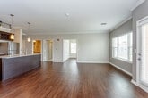 Located at 3311 SW Kessler Dr in Lee's Summit, Missouri, this single-floor residence offers a thoughtfully designed open-concept layout with a refined aesthetic throughout. Rich hardwood flooring flows seamlessly across the main living areas, complemented by crown molding and neutral-toned walls that create a clean, cohesive atmosphere.

The kitchen serves as a central highlight, featuring dark espresso-stained cabinetry that extends to the ceiling, granite countertops, a central island with pendant lighting, and a full suite of stainless steel appliances including a refrigerator, range, and built-in microwave. A wine rack adds a distinctive touch above the upper cabinetry.

The open living and dining area is spacious and bright, with multiple windows allowing natural light to fill the room and a door providing outdoor access. The bedroom offers plush carpeting, a ceiling fan, and generous proportions, with access to a large walk-in closet equipped with built-in wire shelving and hanging systems.

The bathrooms are finished with granite-topped vanities, dark wood cabinetry with brushed nickel hardware, large mirrors, and hardwood flooring, delivering a consistent level of quality found throughout the residence. The overall ambiance is polished, functional, and move-in ready.
