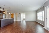 Located at 3311 SW Kessler Dr in Lee's Summit, Missouri, this single-floor residence offers a thoughtfully designed open-concept layout with a refined aesthetic throughout. Rich hardwood flooring flows seamlessly across the main living areas, complemented by crown molding and neutral-toned walls that create a clean, cohesive atmosphere.

The kitchen serves as a central highlight, featuring dark espresso-stained cabinetry that extends to the ceiling, granite countertops, a central island with pendant lighting, and a full suite of stainless steel appliances including a refrigerator, range, and built-in microwave. A wine rack adds a distinctive touch above the upper cabinetry.

The open living and dining area is spacious and bright, with multiple windows allowing natural light to fill the room and a door providing outdoor access. The bedroom offers plush carpeting, a ceiling fan, and generous proportions, with access to a large walk-in closet equipped with built-in wire shelving and hanging systems.

The bathrooms are finished with granite-topped vanities, dark wood cabinetry with brushed nickel hardware, large mirrors, and hardwood flooring, delivering a consistent level of quality found throughout the residence. The overall ambiance is polished, functional, and move-in ready.