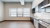 Located at 333 E English St in Wichita, Kansas, this efficiently designed studio unit offers a clean, contemporary aesthetic across its single floor. The open layout maximizes every inch of space, with light-toned hardwood flooring extending throughout and neutral wall tones creating a bright, cohesive atmosphere.

The kitchen is a standout feature, outfitted with dark espresso cabinetry, granite countertops, and a white subway tile backsplash. Stainless steel appliances — including a refrigerator, stove, dishwasher, and microwave — lend a modern, functional edge. A large window with horizontal blinds floods the kitchen and living area with natural light and provides views of the surrounding urban streetscape.

The bathroom is clean and well-appointed, featuring a walk-in shower, a dark-cabineted vanity with a granite countertop, and matching hardwood-style flooring that ties seamlessly into the rest of the unit. An in-unit washer and dryer adds a convenient, practical touch.

The main living area is open and versatile, with exposed structural ceiling elements that hint at the building's industrial character. Ample wall outlets and a straightforward layout make it easy to configure the space to suit a variety of needs. Overall, the unit presents a modern, urban living environment with thoughtful finishes throughout.