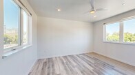 Located at 1026 17th Street in downtown Sacramento, CA, this 2-bedroom, 1-bathroom unit offers a clean, modern aesthetic across a well-organized single-floor layout. Light-toned hardwood-style flooring runs throughout the main living spaces and bedrooms, lending a cohesive and contemporary feel to the entire unit.

The generously sized primary bedroom is a standout feature, offering ample room for furnishings and benefiting from a large window that frames treetop views and invites abundant natural light. A ceiling fan adds comfort and functionality. An expansive walk-in closet serves the primary bedroom, featuring wrap-around shelving and hanging rods on multiple walls — providing exceptional storage capacity.

The second bedroom is equally bright, with its own window overlooking the surrounding neighborhood, crisp white walls, and the same warm flooring found throughout. A connecting hallway ties the rooms together efficiently, maintaining a logical and accessible flow.

The bathroom is finished in a modern, minimalist style with large-format tile flooring, a wall-mounted floating vanity with drawer storage, a frameless mirror, and clean white fixtures. The design prioritizes simplicity and functionality.

Overall, the unit presents a bright, neutral palette with consistent modern finishes, making it a versatile and move-in-ready space in the heart of Sacramento.