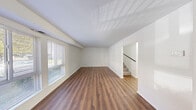 Located at 1313 Johnstons Rd in Norfolk, Virginia, this two-story residence offers a clean, functional layout spread across two levels. The main floor features a generously sized living area finished with rich wood-look laminate flooring and crisp white walls, creating a bright and neutral backdrop. Multiple windows fitted with horizontal blinds allow natural light to fill the space, while an open staircase connects seamlessly to the upper level.

The kitchen is well-appointed with white shaker-style cabinetry extending to the ceiling for ample storage, dark speckled countertops, and a suite of appliances including a gas range, dishwasher, and refrigerator. The wood-look flooring continues here, maintaining a cohesive aesthetic throughout the main living areas.

The upper level houses the bedrooms, each carpeted for comfort and equipped with windows that bring in natural light. At least one bedroom features a sliding closet, providing practical storage. The neutral palette of white walls and light carpet lends a clean, move-in-ready feel to each room.

Overall, the residence presents a straightforward and well-maintained interior with consistent finishes, making it a practical and comfortable home in the Norfolk area.