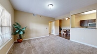 Located in Kansas City, Kansas, this single-story residence offers a well-organized, functional layout with a cohesive design throughout. Warm beige tones carry through the living spaces, complemented by plush carpeting and hard surface flooring in key areas.

The living area is generously proportioned, with neutral walls and ceiling-mounted lighting creating a bright, welcoming atmosphere. It flows openly toward a dining area, which features a ceiling fan and hard-surface flooring. A half-wall pass-through connects this zone to the galley-style kitchen, which is equipped with dark espresso cabinetry, granite-style countertops, and a full suite of appliances including a range, microwave, dishwasher, and refrigerator. A doorway from the kitchen leads directly to the dedicated laundry room, housing a full-size washer and dryer on wood-look flooring.

The bedrooms are carpeted and filled with natural light from large windows with views of the surrounding neighborhood. The primary bathroom features a dual-sink vanity with dark cabinetry and granite-style countertops, while a second bathroom offers a single-sink vanity with matching finishes. The overall design is consistent and practical throughout.