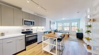 This well-designed one-bedroom, one-bathroom residence at 10 W Westfield Ave in Roselle Park, NJ offers a thoughtfully planned open-concept layout that maximizes every square foot. The combined kitchen and living area forms the heart of the home, showcasing a modern kitchen with sleek grey flat-front cabinetry, under-cabinet lighting, a white geometric tile backsplash, quartz countertops, and a full suite of stainless steel appliances including a range, microwave, dishwasher, and refrigerator. Light wood-tone flooring runs throughout, adding warmth to the contemporary aesthetic. A freestanding breakfast bar with bar seating bridges the kitchen and living area, providing a functional dining space. The living room is filled with natural light from large windows that offer outdoor views, creating a bright and airy ambiance. The bedroom is a calm, neutral retreat with two closets offering generous storage, a window with outdoor views, and easy access to the full bathroom. The bathroom features marble-style tile flooring, a grey vanity with a white countertop, and a clean, minimalist design. Additional spaces include two closets, a utility room, and in-unit laundry, rounding out a complete and practical living experience.