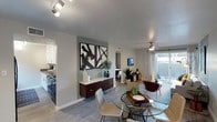 This single-floor residence showcases a thoughtfully designed open-concept layout that seamlessly connects the main living areas. The living room serves as a welcoming centerpiece, featuring wood-look flooring, a ceiling fan with light, and a sliding glass door that opens to a private patio, filling the space with natural light and offering outdoor access. An accent wall in a muted sage-green tone adds depth and visual interest to the living area.

The dining area flows naturally from the living room and kitchen, featuring a glass-top dining table beneath track lighting, creating a functional yet stylish space for entertaining. Adjacent to the dining area, the kitchen is outfitted with crisp white cabinetry equipped with brushed nickel hardware, grey quartz-style countertops, a double stainless steel sink, and a tile backsplash — combining practicality with clean, modern design.

The bedroom is generously sized, featuring the same wood-look flooring, a neutral textured ceiling, and a window that allows natural light to filter in. A grey accent wall anchors the room and complements the contemporary décor. The bathroom includes a full-sized tub and shower combination with chrome fixtures, maintaining the unit's clean, functional aesthetic throughout.