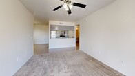 Located at 2651 W Broadway Blvd in Tucson, Arizona, this one-bedroom, one-bathroom unit offers a well-organized single-floor layout that makes efficient use of its space. The combined kitchen and living room serves as the heart of the unit, where a breakfast bar peninsula separates the two areas. The kitchen is equipped with stainless steel appliances, including a full-size refrigerator, range, and microwave, set against light wood-style flooring. The living area features plush carpeting, a ceiling fan with light fixture, and a sliding glass door that opens to a private balcony with scenic views of the surrounding Tucson mountains and palm trees. The carpeted bedroom is a comfortable, well-proportioned retreat filled with natural light from a large window, and includes direct access to a hallway leading to the rest of the unit. A dedicated closet provides additional storage. The bathroom features a full tub-shower combo with brushed nickel fixtures, a vanity with granite-style countertop, and light wood-style flooring that ties the space together. A hallway connects all rooms, contributing to a smooth, functional flow throughout this clean, neutral-toned unit.