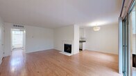 Located on Blix Street in North Hollywood, Los Angeles, this 2-bedroom, 2-bathroom single-story home offers a well-designed layout that balances comfort and functionality. The spacious living room is a standout feature, showcasing warm hardwood flooring, a classic white-framed fireplace, and sliding glass doors that open to a private patio, filling the space with natural light and providing a seamless indoor-outdoor connection. The kitchen is designed in a galley style with white shaker cabinetry, dark countertops, tile flooring, and a full suite of stainless steel appliances including a gas range, over-the-range microwave, dishwasher, and refrigerator. The primary bedroom is generously sized, featuring plush carpet and a multi-pane window that invites natural light and greenery views. The second bedroom is equally well-appointed with soft carpeting and clean white walls. Both bathrooms are finished with tile flooring, white vanity cabinetry, dark countertops, and sliding glass shower enclosures — one with a shower/tub combination and the other with a walk-in shower. A hallway and dedicated closet provide additional storage. The home's clean, neutral palette throughout creates a bright and inviting atmosphere.