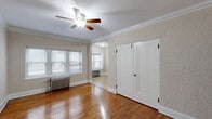 Located at 1743 N Cambridge Ave in Milwaukee's vibrant 53202 zip code, this single-floor unit offers a well-organized layout comprising a living room, kitchen, hallway, and bathroom. The living room is a welcoming space highlighted by warm hardwood flooring, elegant crown molding, and a ceiling fan with light fixture. A trio of windows fitted with horizontal blinds allows natural light to fill the room, while a classic cast-iron radiator provides efficient heating. The kitchen is thoughtfully designed with rich dark-espresso cabinetry, light countertops, and tile flooring. Stainless steel appliances — including a refrigerator, dishwasher, and range — lend a modern touch, and a window over the counter brings in additional natural light. A cast-iron radiator is also present in the kitchen, consistent with the building's traditional heating system. The bathroom features white subway tile in the walk-in shower, a clean white vanity with sink, a medicine cabinet mirror, and brushed nickel fixtures, creating a crisp, functional space. The hallway connects the rooms efficiently, contributing to the unit's practical flow. Overall, the space blends classic architectural character with updated finishes.