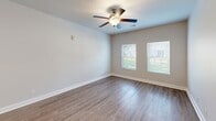Located at 1032 Mohawk St in Savannah, GA, this single-story residence offers a thoughtfully designed floor plan with two bedrooms, two bathrooms, and dedicated laundry space. The interior is unified by wood-look flooring throughout, neutral-toned walls, and clean white trim, creating a consistent and modern aesthetic.

The open-concept kitchen and living area serves as the heart of the home. The kitchen features dark espresso cabinetry extending to the ceiling for ample storage, granite countertops, a dual-basin sink, pendant lighting, and a full suite of stainless steel appliances including a range, microwave, and refrigerator. A kitchen island with granite counters provides additional prep and seating space.

The primary bedroom is a comfortable size, offering a dedicated closet with wire shelving and direct access to one of the two bathrooms. The second bedroom benefits from dual windows that invite natural light and views of the surrounding greenery, complemented by a ceiling fan. Both bathrooms mirror the kitchen's design with dark vanity cabinetry, granite countertops, and wood-look flooring.

A dedicated laundry room includes washer and dryer hookups, rounding out the practical and functional layout of this Savannah residence.