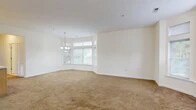 Located at 1200 Regency Ct in Middletown, NY, this two-story residence offers 1 bedroom and 2 bathrooms across a thoughtfully designed layout. The main living level hosts the majority of the space, featuring a combined living and dining room anchored by a striking bay window that floods the area with natural light. A decorative chandelier adds an elegant touch overhead, while warm beige carpeting runs throughout the living spaces. The kitchen is well-equipped with light wood cabinetry, stainless steel appliances including a gas range, microwave, dishwasher, and refrigerator, complemented by tile flooring and ample counter space. A den provides additional flexible living space, and a convenient hallway connects the key areas of the floor. The spacious primary bedroom features carpeted floors, a window with natural light, and access to a dedicated walk-in closet. Two bathrooms serve the home, finished with tile flooring and clean, neutral tones. Additional practical features include in-unit laundry, a utility room, multiple closets for storage, and a balcony with views of the surrounding tree-lined community. Carpeted stairs with a wooden handrail connect the two levels, completing this functional and comfortable home.