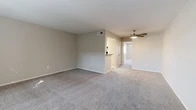 Located at 2218 Water Dance Circle in Arlington, TX, this two-bedroom, one-bathroom residence offers a comfortable and efficiently designed single-floor layout. The open living area is finished with plush carpet and neutral-toned walls, creating a clean and welcoming atmosphere. A ceiling fan with a light fixture adds both functionality and a classic touch to the space. The kitchen is thoughtfully appointed with white shaker-style cabinetry, speckled granite-look countertops, a double-basin sink, and wood-look vinyl plank flooring, lending a modern and fresh aesthetic. A pass-through bar connects the kitchen to the living area, enhancing the sense of openness. The carpeted hallway leads to two well-proportioned bedrooms, each featuring ceiling fans with lighting and windows that allow natural light to filter in. The primary bedroom offers a generous amount of space for comfortable furnishing. The bathroom is well-finished with a white vanity, speckled countertop, an undermount sink, and wood-look vinyl plank flooring. Two closets provide ample storage throughout the unit. The overall design is clean and neutral, making it a versatile and move-in-ready living space.