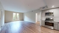 Located at 111 N Madison Ave in Pasadena, CA, this well-appointed 2-bedroom, 2-bathroom residence offers a thoughtfully designed single-floor layout. The open-concept living and kitchen area serves as the heart of the home, featuring light hardwood-style flooring that extends throughout the main living spaces, creating a bright and cohesive feel. The kitchen is outfitted with stainless steel appliances including a gas range and over-the-range microwave, grey shaker-style cabinetry, white quartz countertops, and a classic white subway tile backsplash. A set of French doors in the living area floods the space with natural light and provides direct access to an outdoor area with views of surrounding greenery. The primary bedroom is a generously sized retreat with hardwood-style flooring and French doors that further connect the interior to the outdoors. The second bedroom features plush carpeting and a window offering natural light and outdoor views, along with a built-in closet. Both bathrooms are finished with large-format tile flooring, white vanities with quartz countertops, and framed mirrors. One bathroom conveniently houses an in-unit washer. The hallway and entrance complete this clean, modern layout designed for comfortable everyday living.