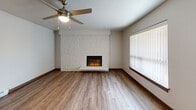 This single-floor, 2-bedroom, 1-bathroom apartment at 650 SE 162nd Ave in Portland, Oregon offers a practical and comfortable layout with consistent wood-look flooring throughout. The living room serves as the focal point of the unit, featuring a striking white stone-accented fireplace wall, a ceiling fan with light, and vertical blinds allowing natural light. The open dining and kitchen area includes rich cherry-toned cabinetry, granite-style countertops, a stainless steel refrigerator, and a range, with a window overlooking the exterior and baseboard heating below. Both bedrooms are well-proportioned, each equipped with ceiling fans, baseboard heaters, and windows with vertical blinds that bring in outdoor views and natural light. The primary bedroom offers generous closet space with double-door panel closets. The bathroom features a dark wood vanity with a granite-style countertop, a mirror, and a clean, streamlined design. A hallway connects the rooms efficiently, and the unit provides an abundance of closet storage throughout. The neutral color palette and updated finishes create a clean, move-in-ready atmosphere throughout the entire space.