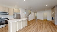 Located on N Dogwood St in Camas, WA, this contemporary three-floor home offers 3 bedrooms and 4 bathrooms thoughtfully distributed across three well-defined levels. The entry-level floor provides a compact and functional footprint, while the main living floor serves as the heart of the home. Here, an open-concept kitchen and living area is bathed in natural light and features warm light wood LVP flooring throughout. The kitchen is outfitted with light birch cabinetry, stainless steel appliances including a refrigerator, range, microwave, and dishwasher, and a sleek white quartz island and countertops — creating a bright, modern aesthetic. A staircase connects all three levels seamlessly via hallways that maintain the home's clean, minimal design language. The upper floor hosts the bedrooms, including a generously sized primary suite with a walk-in closet featuring wire shelving, plush carpet flooring, and a private ensuite bathroom. The ensuite is finished with light wood cabinetry, white quartz counters, a large vanity mirror, and a glass-enclosed shower. Additional bedrooms offer carpet flooring and ample natural light through multiple windows. A dedicated laundry room with full-size LG washer and dryer adds everyday convenience. Four bathrooms in total ensure comfort for residents and guests alike.