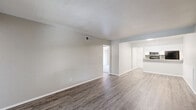 Located at 7913 Harwood Rd in North Richland Hills, TX, this 2-bedroom, 3-bathroom residence offers a thoughtfully arranged single-floor layout with a clean, modern aesthetic throughout. The open-concept living area features wood-look luxury vinyl plank flooring and neutral tones, flowing seamlessly into a well-appointed kitchen. The kitchen is equipped with white shaker-style cabinetry, granite countertops, a tile backsplash, stainless steel appliances including a microwave and dishwasher, and a black refrigerator and range. The bedrooms are carpeted and feature ceiling fans with light fixtures and windows that bring in natural light. The spacious primary bedroom includes access to an outdoor area through a sliding glass door. The bathrooms are finished with granite-topped white vanities, vessel sinks, and framed mirrors, while the full bath features a tub-shower combination with wood-look flooring. A dedicated laundry area houses a stacked GE washer and dryer unit for added convenience. Throughout the residence, textured walls, clean white trim, and consistent flooring choices create a cohesive and move-in-ready environment.