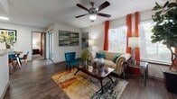 This single-floor residence offers a thoughtfully designed layout that balances comfort and functionality across its living spaces. The living room serves as the heart of the home, featuring wood-look flooring, a ceiling fan, textured ceilings, and a large window dressed with vibrant curtains that invite natural light. A sliding glass door provides access to the outdoors, enhancing the open feel of the space.

The kitchen is efficiently organized with white cabinetry, granite-style countertops, a tile backsplash, and stainless steel appliances including a gas range and full-sized refrigerator, all set over matching wood-look flooring.

Two carpeted bedrooms offer comfortable retreats, each equipped with ceiling fans, ample natural light from large windows with blinds, and generous closet space. The primary bedroom features a walk-in closet with built-in shelving, while both rooms provide a calm, restful atmosphere.

The two bathrooms are finished with white cabinetry, marble-look countertops, dark wood-framed mirrors, and wood-look flooring. One bathroom includes a shower with a glass enclosure, while both feature overhead storage cabinets and brushed nickel hardware accents, lending a clean and contemporary aesthetic throughout.
