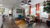This single-floor residence offers a thoughtfully designed layout that balances comfort and functionality across its living spaces. The living room serves as the heart of the home, featuring wood-look flooring, a ceiling fan, textured ceilings, and a large window dressed with vibrant curtains that invite natural light. A sliding glass door provides access to the outdoors, enhancing the open feel of the space.

The kitchen is efficiently organized with white cabinetry, granite-style countertops, a tile backsplash, and stainless steel appliances including a gas range and full-sized refrigerator, all set over matching wood-look flooring.

Two carpeted bedrooms offer comfortable retreats, each equipped with ceiling fans, ample natural light from large windows with blinds, and generous closet space. The primary bedroom features a walk-in closet with built-in shelving, while both rooms provide a calm, restful atmosphere.

The two bathrooms are finished with white cabinetry, marble-look countertops, dark wood-framed mirrors, and wood-look flooring. One bathroom includes a shower with a glass enclosure, while both feature overhead storage cabinets and brushed nickel hardware accents, lending a clean and contemporary aesthetic throughout.