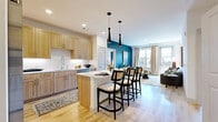 Located at 505 W Community Center Dr in Northglenn, Colorado, this thoughtfully designed 2-bedroom, 2-bathroom residence offers a modern and comfortable living experience across a single floor. The open-concept kitchen is a standout feature, showcasing light wood cabinetry that extends to the ceiling, white quartz countertops, a classic subway tile backsplash with under-cabinet lighting, stainless steel appliances, and a central island with seating for multiple guests — all set on warm light wood flooring. The living room is bright and inviting, anchored by a bold teal accent wall, large windows, and a glass door opening to a private balcony that brings in abundant natural light. Both bedrooms offer plush carpeting, generous windows with views of the surrounding community, and a calm, restful ambiance with tasteful accent walls. The two bathrooms are clean and contemporary, each featuring light wood vanities with white countertops, tiled soaking tubs, and light wood-look flooring. A dedicated in-unit laundry area with full-size washer and dryer adds everyday convenience. Together, the rooms create a cohesive, modern aesthetic that balances style and functionality throughout.