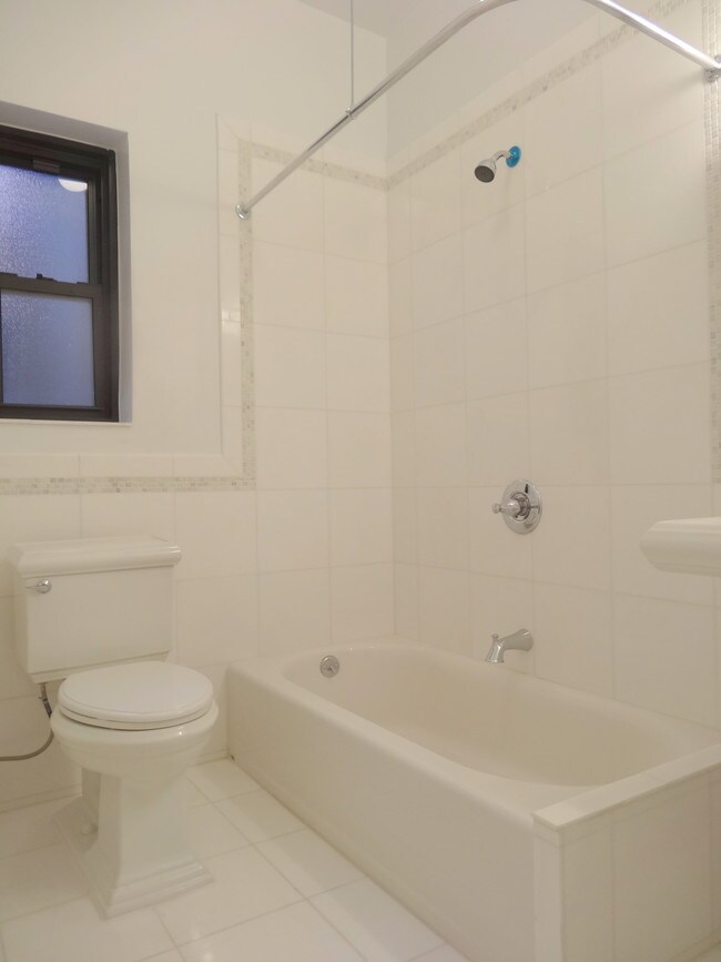 Baño de azulejos blancos - Grand St. & Mott St.