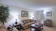 Located at 100 Fox Meadow Dr in Maple Shade, NJ, this two-story home offers a comfortable and well-appointed living environment. The main level features a spacious living room with soft, neutral-toned carpeting and warm white walls that create a bright and inviting atmosphere. The living room is anchored by a cozy seating area and accented with classic dark wood end tables and a matching coffee table, adding a touch of traditional elegance. A framed landscape artwork on the wall contributes to the room's refined yet approachable aesthetic. A staircase with a decorative wrought iron railing rises from the living area, serving as a focal point while providing access to the second floor. The overall design of the home embraces a timeless, neutral palette that allows for versatile decorating possibilities. The layout flows naturally between living spaces, making it well-suited for both everyday living and entertaining. The combination of carpeted floors, ample ambient lighting, and thoughtfully proportioned rooms gives the home a warm, lived-in character throughout both levels.