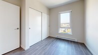 Located on the 16th floor at 819 Yates Street in the heart of Victoria, BC, this contemporary 2-bedroom, 2-bathroom residence offers a well-designed layout with modern finishes throughout. The unit features light grey wood-look flooring that flows consistently across all rooms, complemented by neutral-toned walls that create a bright, clean aesthetic.

The kitchen is a standout feature, showcasing dark wood-grain cabinetry, quartz countertops, a subway tile backsplash, and a full suite of stainless steel appliances including a built-in microwave, electric range, dishwasher, and refrigerator. A window above the sink frames elevated city views, filling the space with natural light.

Both bedrooms are well-proportioned and include sliding panel closets and large windows offering expansive views of Victoria's skyline and surrounding cityscape. The primary bedroom is serviced by a modern ensuite bathroom featuring a glass-enclosed walk-in shower with a ceiling-mounted rain head, dark wood vanity, and quartz countertop. A second bathroom includes a bathtub with tiled surround and matching vanity cabinetry. The layout is completed by a hallway and dedicated closet space, providing practical storage throughout.